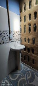 a bathroom with a sink and a wall with windows at Eco Hostel Lunar in Soure