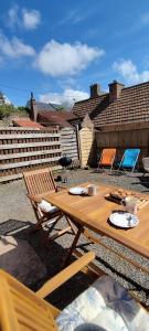 a wooden picnic table and chairs on a patio at Coeur de granit rose, meublé alliant le charme de l'authentique breton et du confort, classé 3 étoiles, à 5mn de 13 plages de la réputée cote de granit rose in Trégastel +59 photos