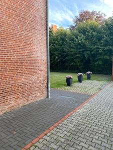a brick wall with two potted plants in a courtyard at Appartementhaus EMDEN in Emden
