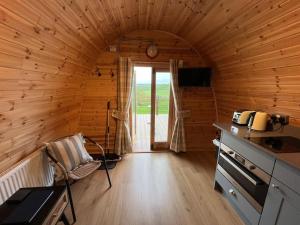 a room with a kitchen in a wooden cabin at The Pod Patch - Bryn Pod in Bishops Castle