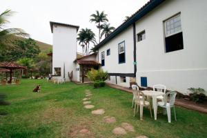 a yard with a table and chairs next to a building at Hotel Fazenda Palmeiras in Rio Casca