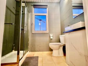 a bathroom with a shower and a toilet and a window at SwissPorto Guest House in Porto