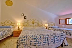 1 dormitorio con 2 camas y 2 lámparas en Casa Gabriella, en Fetovaia