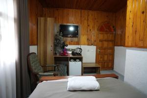Habitación con cama y cocina con paredes de madera. en OzenTurku Hotel, en Pamukkale