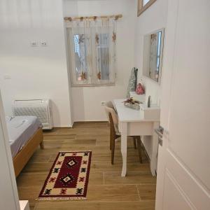 een slaapkamer met een tafel, een bed en een bureau bij Happy Blue 2 in Vlorë