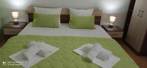 a bedroom with a green bed with towels on it at ANTONIJ Apartment Gevgelija in Gevgelija