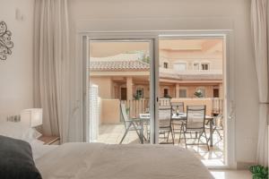 a bedroom with a bed and a balcony with a table and chairs at Aloha Hill Club LLuxury 5 Star Golf Resort Near Puerto Banus and Marbella in Marbella