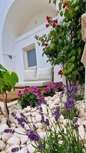 a garden with flowers in front of a building at Corte Dioniso Eco Apartments & Suites in Crispiano