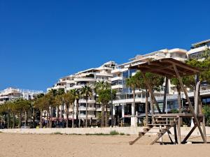 ein großes Apartmenthaus am Strand mit einer Bank in der Unterkunft Vlora Bay in Vlorë