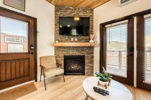 a living room with a fireplace and a flat screen tv at Pikes Peak Boutique Retreat! in Woodland Park