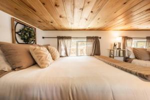 a large white bed in a room with wooden ceilings at Pikes Peak Boutique Retreat! in Woodland Park