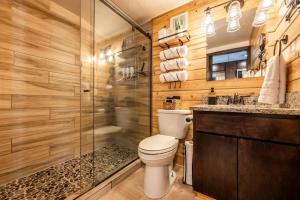 a bathroom with a toilet and a glass shower at Pikes Peak Boutique Retreat! in Woodland Park +31 photos