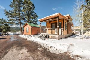 a house with snow on the side of the road at Pikes Peak Boutique Retreat! in Woodland Park