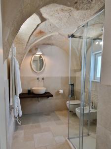a bathroom with a sink and a glass shower at Corte Dioniso Eco Apartments & Suites in Crispiano