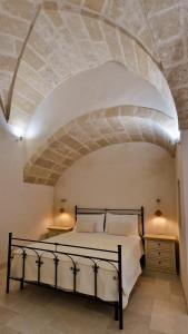 a bedroom with a bed with a stone ceiling at Corte Dioniso Eco Apartments & Suites in Crispiano