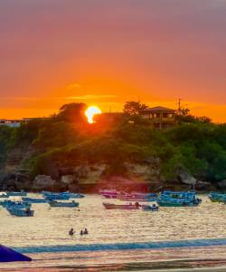 a sunset over a beach with boats in the water at CASA DEL MAR in Ayangue
