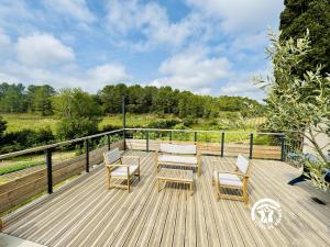 a wooden deck with two chairs and a table and chairs at Domaine de Gazel in Laure-Minervois