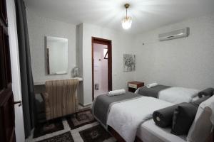 a hotel room with two beds and a mirror at OzenTurku Hotel in Pamukkale