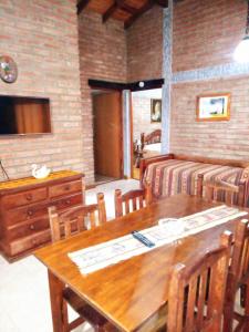 comedor con mesa de madera y sillas en Cabañas Legado Alemán en Villa General Belgrano