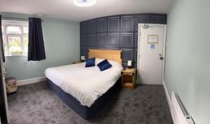 a bedroom with a large bed with blue pillows at The Crafty Cow in Bristol