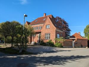 a large brick house with a tree in front of it at Gæstehus Sorø Sø in Sorø