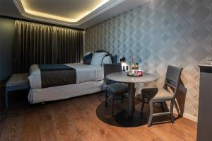 ein Hotelzimmer mit Bett, Tisch und Stühlen in der Unterkunft Hive Nápoles by G Hotels in Mexiko-Stadt
