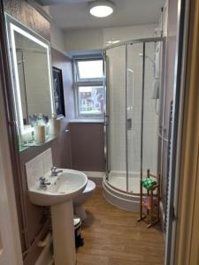 uma casa de banho com um chuveiro, um lavatório e um WC. em The Crafty Cow em Bristol