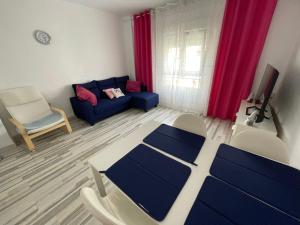 sala de estar con sofá azul y cortinas rojas en Piso tranquilo y luminoso en Valencia, en Valencia