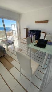 Habitación con mesa, sillas y ordenador portátil. en Beachfront apartment - La Mata, en Torrevieja