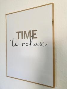 a sign that says time to relax on a white wall at city apartment nice & comfy in Krefeld