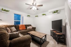een woonkamer met een bank en een flatscreen-tv bij The Canopy: A Peaceful Home Nestled in Sugarhouse in Salt Lake City