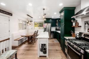 een keuken met groene kasten en een houten tafel bij The Canopy: A Peaceful Home Nestled in Sugarhouse in Salt Lake City