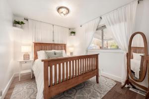 een slaapkamer met een houten bed en een spiegel bij The Canopy: A Peaceful Home Nestled in Sugarhouse in Salt Lake City