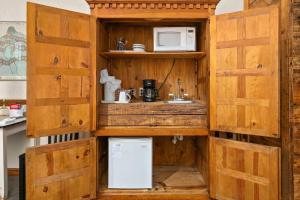 a small kitchen with wooden cabinets and a refrigerator at #26 at Gruene Silo Inn in New Braunfels