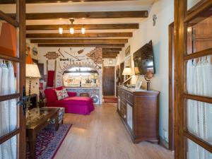uma sala de estar com um sofá vermelho e uma lareira em Ca Bellavista em Vega de San Mateo