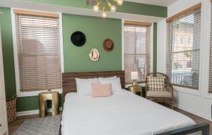 a bedroom with a bed with green walls and windows at 20% OFF I Ybor City Gem I Steps to 7th Ave in Tampa