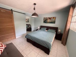 a bedroom with a bed with a blue comforter at Kas di BaMi A-194 op Seru Coral Resort - Ruim appartement met groot zwembad en tropische tuin in Willemstad +38 photos
