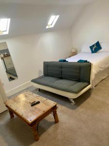 a bedroom with a bed and a couch and a table at JP Short Stays in Upton upon Severn