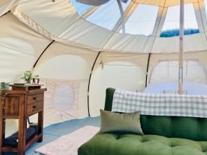 a room with a green couch in a tent at Luxury Stargazing Glamping - Seren Aur with Hot Tub in Llanidloes