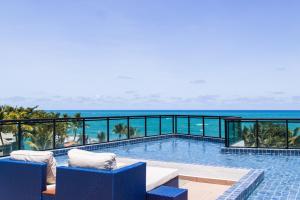 ein Swimmingpool mit Blick auf das Meer in der Unterkunft Maracaipe Estrela Flat110 in Porto De Galinhas