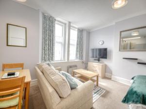 a living room with a couch and a table at Apartment 4 - Large studio - Sea Front location - Rear views-Free Parking in Paignton +5 photos