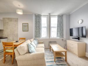a living room with a couch and a table at Apartment 4 - Large studio - Sea Front location - Rear views-Free Parking in Paignton