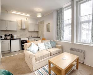 a living room with a couch and a table at Apartment 4 - Large studio - Sea Front location - Rear views-Free Parking in Paignton