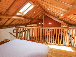a attic room with a bed and a wooden ceiling at The Shippon in Conwy