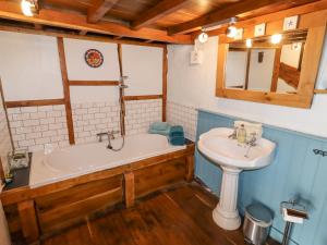 a bathroom with a sink and a tub and a toilet at The Shippon in Conwy +26 photos