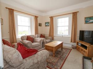 a living room with two couches and a tv at Old Higher Lighthouse Stopes Cottage in Southwell