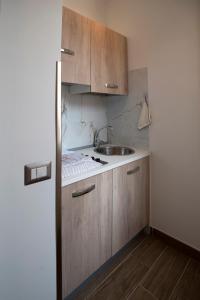 eine Küche mit Holzschränken und einem Waschbecken in der Unterkunft Il Vicoletto sul Mare in Ischia