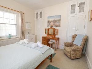 a bedroom with a bed and a chair at Old Higher Lighthouse Stopes Cottage in Southwell +47 photos