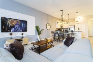a living room with two white couches and a kitchen at Lovely Condos 18 Minutes away from Disney! in Kissimmee