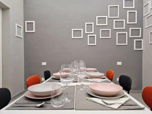 Un comedor con una mesa con platos y copas de vino. en MIRA Apartment, en Catania 26 fotos más